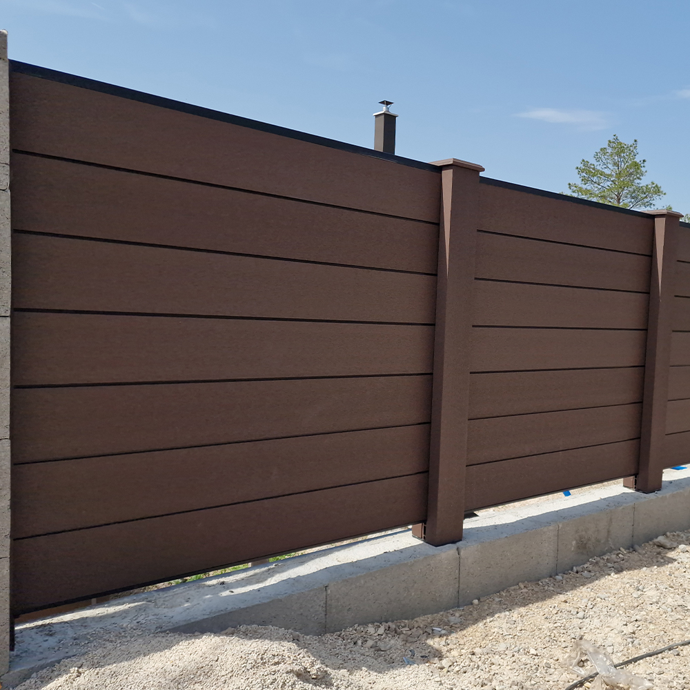 Zárt WPC kerítés – barna színű referencia kivitelezés oldalhatáron.